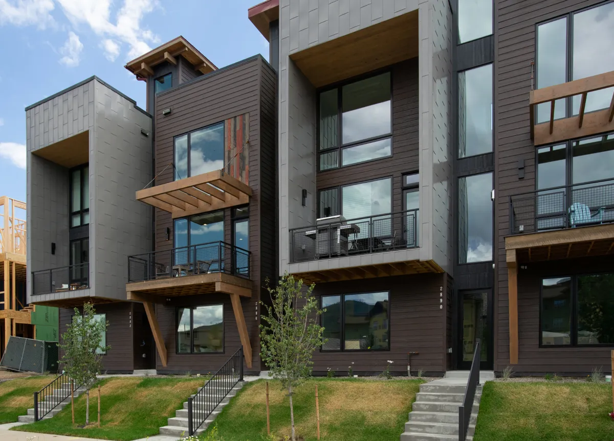 A striking exterior shot showcasing the modern architecture of the townhome, featuring balconies, expansive windows, and landscaped surroundings. The image radiates a sophisticated and welcoming vibe, perfect for gatherings or quiet moments outdoors.