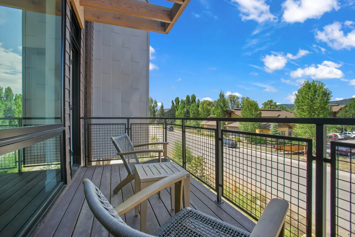 An outdoor balcony seating area with railings, offering panoramic views of the surrounding landscape. The tranquil setting is ideal for morning coffee, stargazing, or gathering with family and friends in the fresh mountain air.