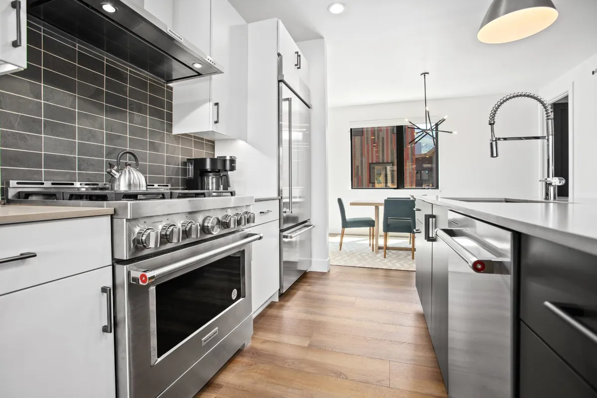 A sleek, contemporary kitchen and dining area with a stainless steel range, modern cabinetry, and an inviting dining space. The scene is bright and welcoming, ideal for post-adventure gatherings and meal prep.